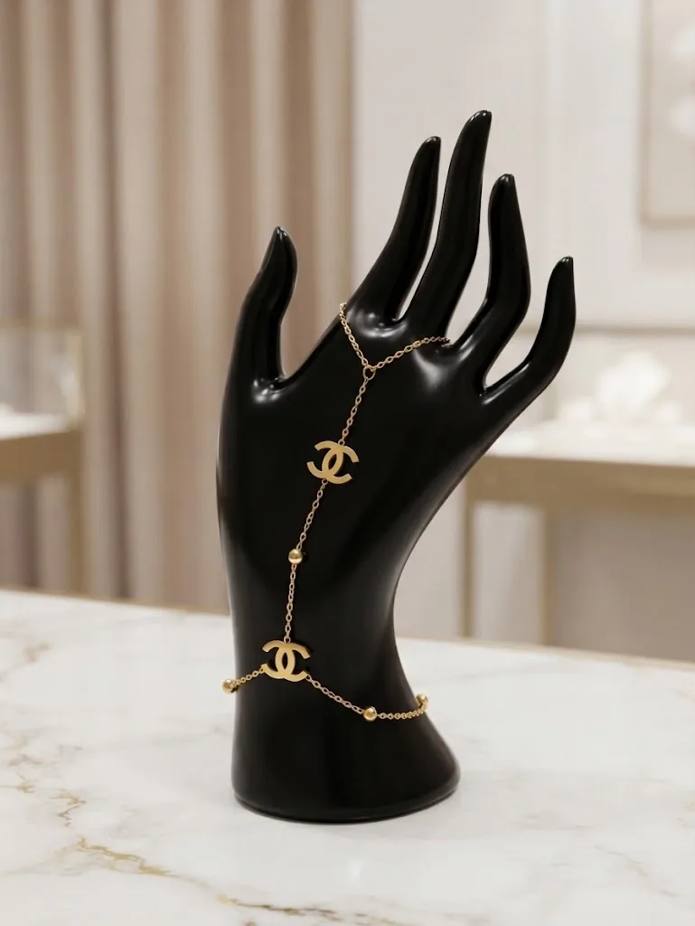 قطعة عصرية وراقية تتكوّن من سلسلة ذهبية رفيعة تربط المعصم بخاتم الإصبع    CHANNEL    Bracelet de Main Chaîne Élégance Dorée