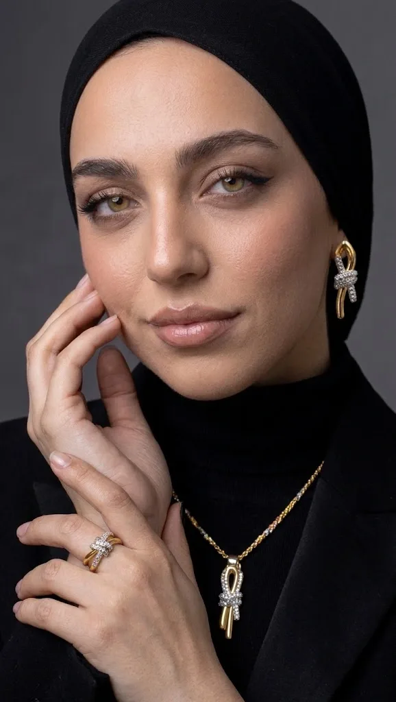 طقم العقدة الذهبي: سوار، خاتم، عقد وحلق بتصميم فاخر وأحجار متلألئة. اختيارك المثالي لإطلالة تخطف الأنظار            La parure Nœud Doré : bracelet, bague, collier et boucles d’oreilles au design luxueux, sertis de pierres scintillantes. Votre choix idéal