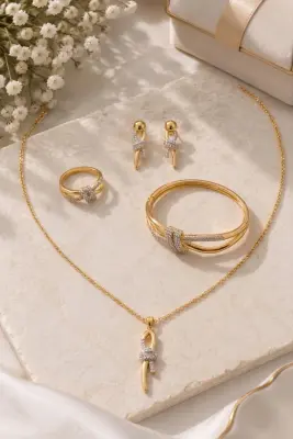 طقم العقدة الذهبي: سوار، خاتم، عقد وحلق بتصميم فاخر وأحجار متلألئة. اختيارك المثالي لإطلالة تخطف الأنظار            La parure Nœud Doré : bracelet, bague, collier et boucles d’oreilles au design luxueux, sertis de pierres scintillantes. Votre choix idéal
